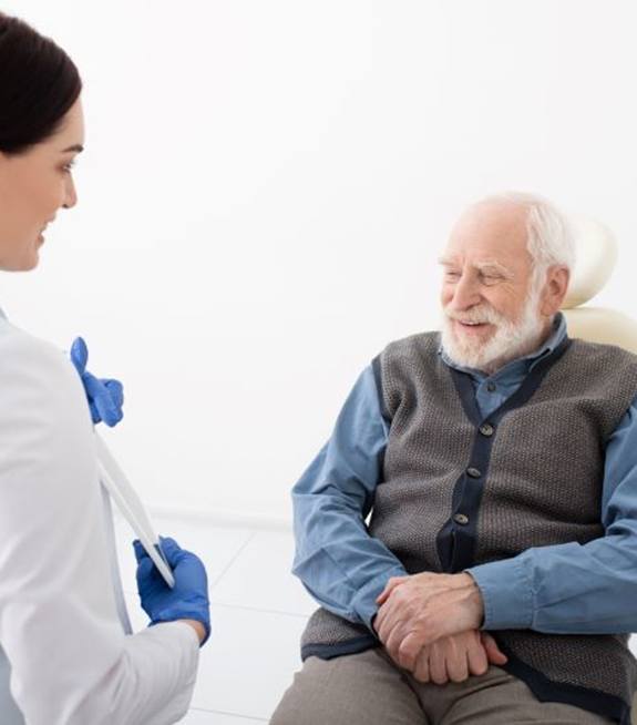 Senior man talking with dental team member