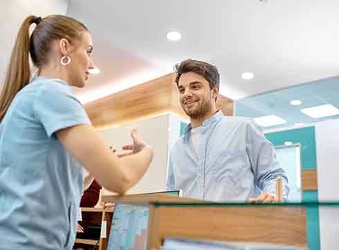 front desk personnel talking to a patient