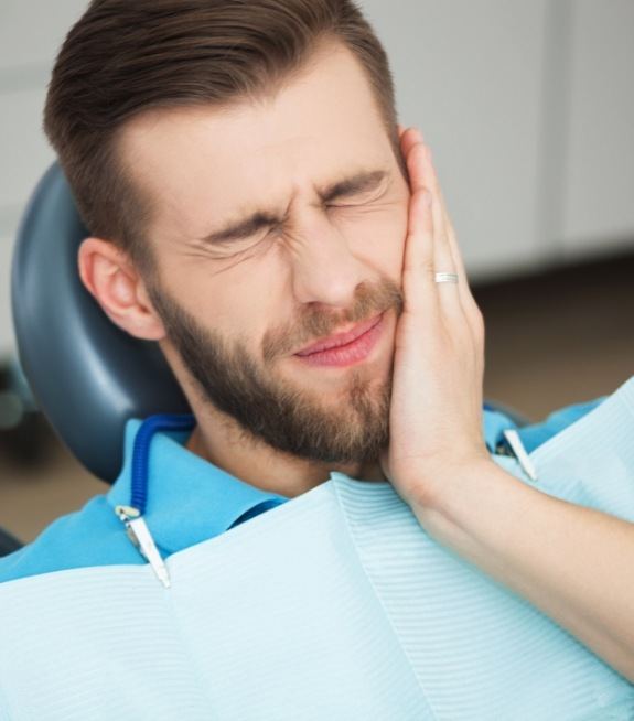 Man holding his cheek in pain