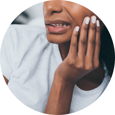 Close up of person wincing and holding their cheek in pain