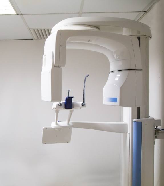 Cone beam imaging scanner standing against white wall