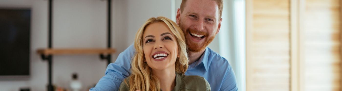 Man and woman smiling and hugging after periodontal therapy in Corpus Christi