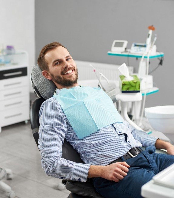 Man smiling and leaning back in dental chair