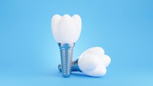 Two dental implants and restorations against blue background
