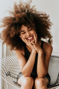 Smiling woman with her hands on her face