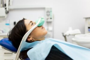 Young woman being sedated at dentist's office.